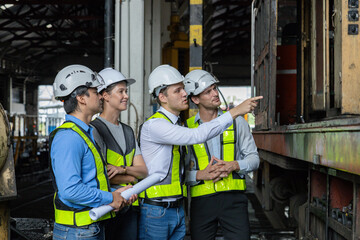 Chief engineer consults and analyzes train diesel engine problems Railway tracks in a train depot
