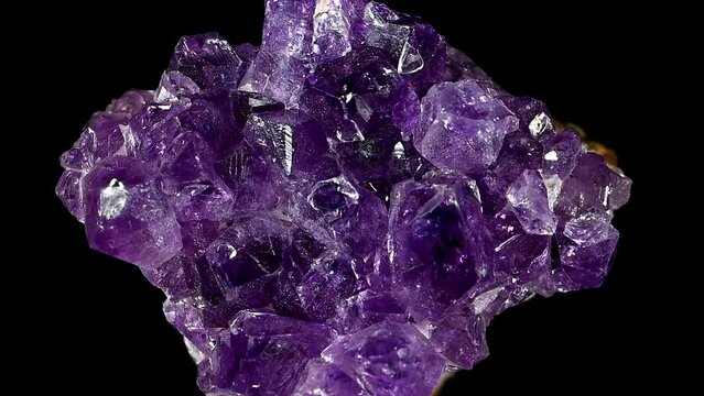 Amethyst crystals (purple quartz) sample rotating slowly against a black background.	