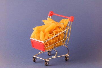 Pasta in a shopping basket on a blue background