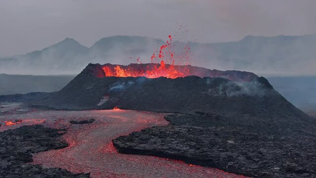 Aerial drone view over river of molten hot lava erupting from the Litlihrutur Iceland volcano and flows through dark rock in 2023. Tourist attraction to beautiful and dangerous disaster.
