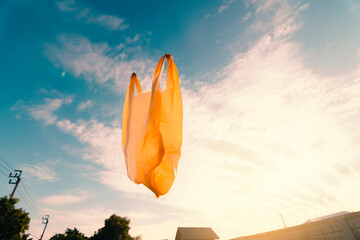 Used plastic bags floating in the air and sunset sky, garbage and pollution, global warming, and...