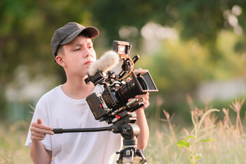 Teenage boy operating a digital camera to tell the story in the new movie. content creator, and...