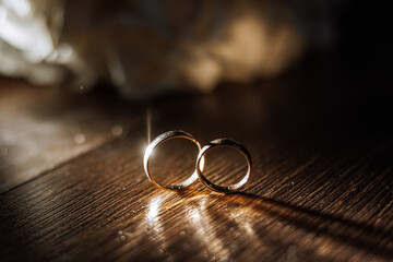 Stylish wedding rings on a wooden table. Promises engagement. Luxury marriage and wedding accessory...