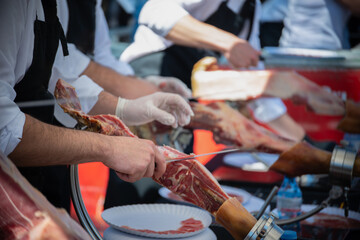 Fototapeta na wymiar Ham cutting master, professional knife master, Cortador de jamon, man cutting jamon ham placed in a stand