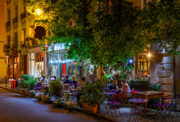 Cozy street with tables of cafe in Paris, France. Night cityscape of Paris. Architecture and landmarks of Paris. - 736264490