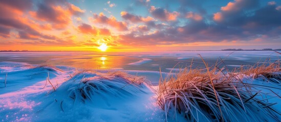 A breathtaking view of a stunning sunset reflecting on a frozen lake - obrazy, fototapety, plakaty