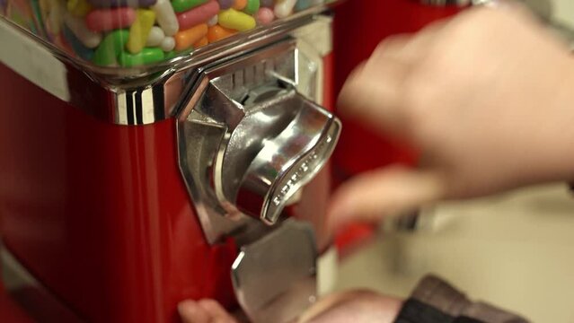 child puts a coin into the vending machine and receives sweets
