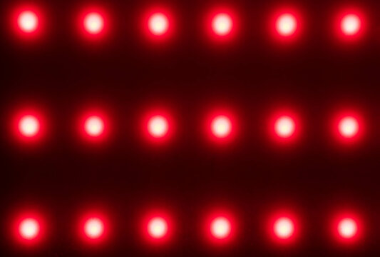 red blurred dots on black background, red light therapy