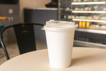 There is a cup of latte on a table in a coffee shop. Lifestyle