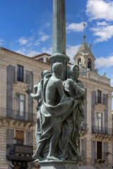 Fototapeta na wymiar Statues of Fratelle Pii on a street lamp on University Square, Catania, Sicily, Italy