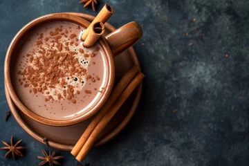  Top view of a square image showing a vintage mug of hot chocolate with cinnamon sticks on a dark background © The Big L