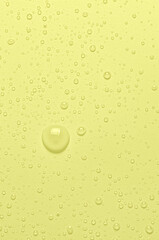 Drops of micellar water or cosmetic tonic on a yellow background. Closeup, macro photography. Copy space