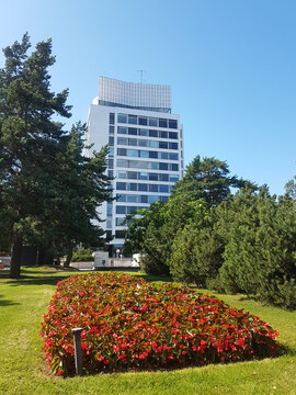 Tall building, red flowers, trees and bushes in Espoo, Finland