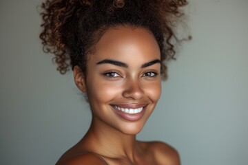 Portrait of a smiling beautiful African American woman with a clean and healthy complexion showcasing a stylish hairstyle with a bun