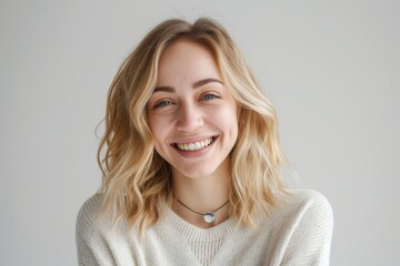 Smiling young blonde woman on a white background