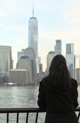 woman looking at downtown manhattan nyc skyline (after sunset, night time)  world trade center...