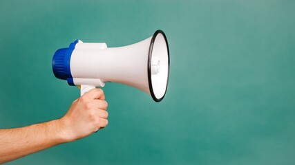 Young male hand holding a white megaphone