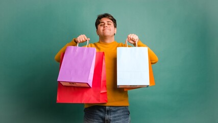 Happy ethnic young man showing shopping bags