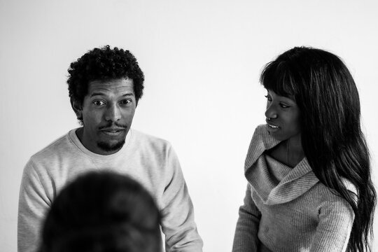 African american couple sitting at psychologist's office for a couples therapy - Couple relationship concept in trouble and crisis - Focus on man's face -  Black and white editing
