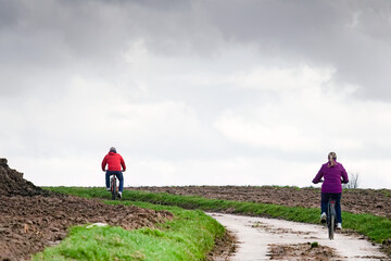 Couple de cyclistes sur un chemin de remembrement dans la campagne.