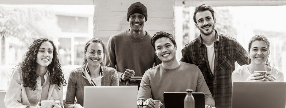 Horizontal banner or header with smiling multiethnic coworkers looking at camera making team picture in modern office together - Diverse work group or department laugh posing for photo at workplace