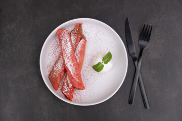 Plate with sweet pink pancakes and ice cream top view on dark background