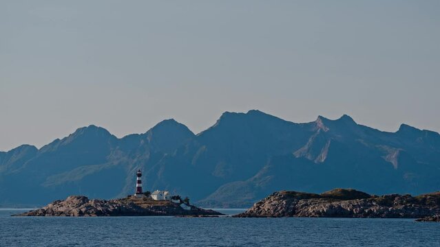Skrova Lighthouse On Coastal Skerry Against Misty Peaks