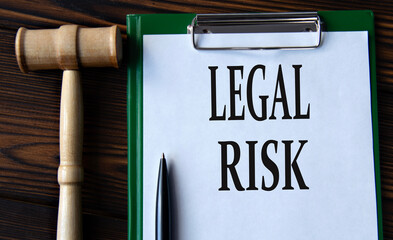 LEGAL RISK - words on a white sheet with a judge's gavel
