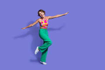 Obraz premium Photo of positive optimistic woman fly with open hands travel agency ad empty space isolated on purple color background