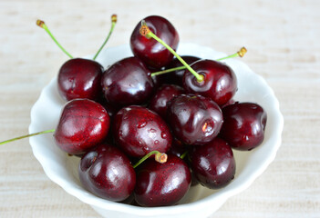 bowl with cherries covered with water drops close up 