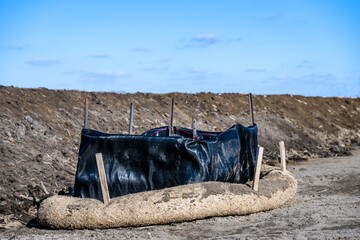 Filter sock staked around a storm intake at a construction site