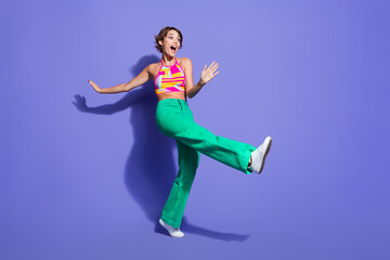 Fototapeta na wymiar Full length photo of overjoyed lovely girl wear bright outfit celebrate festive event look empty space isolated on purple color background
