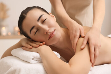 Obraz na płótnie Canvas Woman receiving massage on couch in spa salon