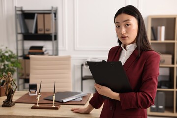 Fototapeta premium Portrait of notary with clipboard in office. Space for text