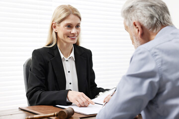 Senior man signing document in lawyer's office