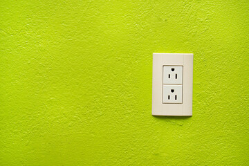 Contacto de electricidad en una pared verde
