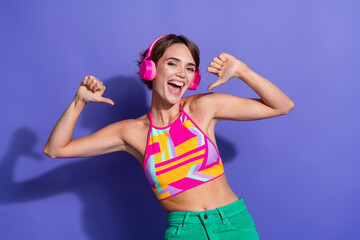 Photo of young overjoyed funny lady in bright pink crop top point fingers herself summertime party dj isolated on violet color background