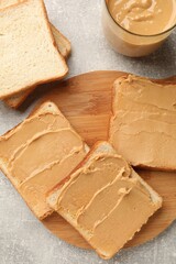 Obraz na płótnie Canvas Tasty peanut butter sandwiches on gray table, flat lay
