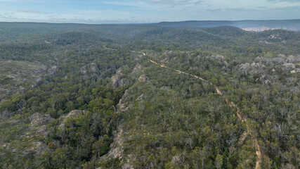 Obraz premium Drone aerial photograph of a long and narrow vehicle dirt track running along a rocky mountain ridge in the Blue Mountains in New South Wales in Australia