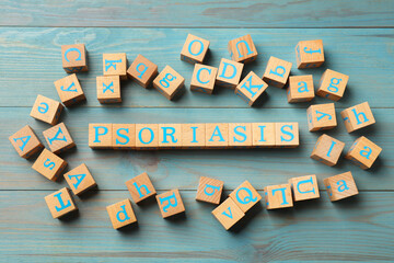 Word Psoriasis made of cubes with letters on wooden table, flat lay