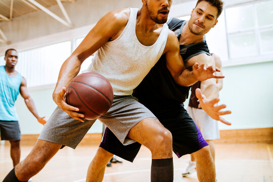 Young men playing basketball in a indoor gym