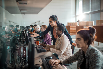 Diverse young students using computer in university lab