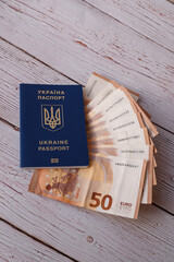 Ukraine passport for traveling in Europe against the background of Euro banknotes and wood. Concept...