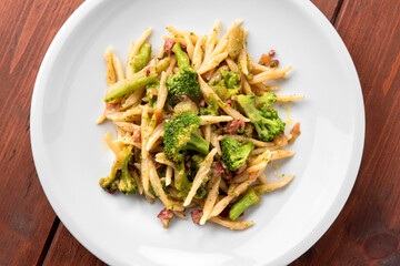 Veduta dall'alto di un piatto di pasta condita con broccoli e pancetta, cibo italiano 