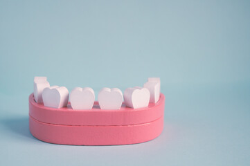 Model of a jaw with teeth on a blue background. Wooden toy teeth and mouth. Dental health medical...