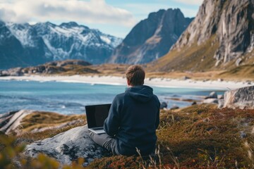 Fototapeta premium A person sits on a sturdy rock while using their laptop to work, providing a scenic view of the expansive ocean, An IT professional working remotely from a serene location, AI Generated