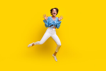 Fototapeta na wymiar Full size photo of overjoyed ecstatic woman wear print blouse flying show palms astonished staring isolated on yellow color background