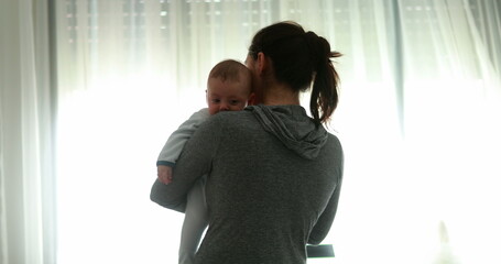 Revealing mother holding baby infant newborn at home good for transition