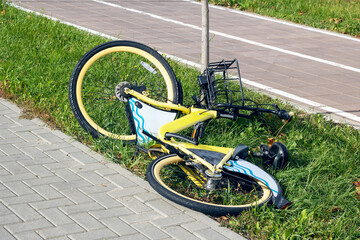 Yellow bicycle lying on the grass closeup