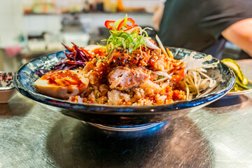 Spicy asian bowl with chicken, shrimp, seed, egg and vegetable in blue bowl - 736427832